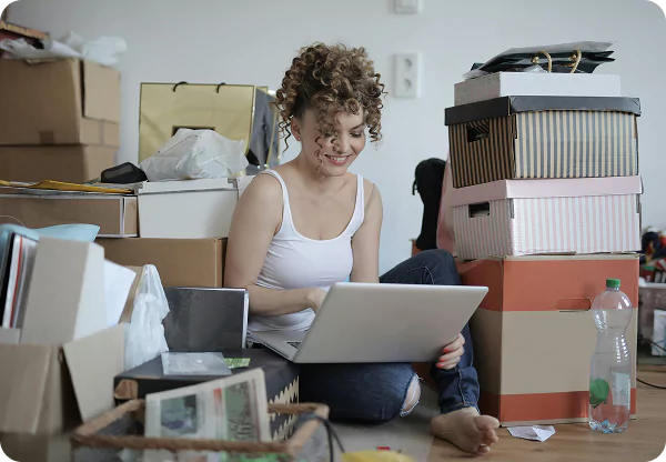 A woman sitting on the floor, focused on her laptop